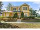 Beautiful two-story home featuring a manicured lawn, mature trees, and a welcoming front porch at 3304 Cat Brier Trl, Harmony, FL 34773