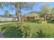 Well-maintained home exterior with green lawn, mature trees, and a side-entry two-car garage at 3304 Cat Brier Trl, Harmony, FL 34773