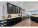 Modern kitchen with sleek black cabinets, stainless steel appliances, and views of the adjoining living space at 3304 Cat Brier Trl, Harmony, FL 34773