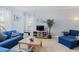 Bright living room with neutral walls, complemented by a comfortable blue sofa and natural light from the window at 3304 Cat Brier Trl, Harmony, FL 34773
