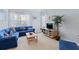 Bright living room with neutral walls, complemented by a comfortable blue sofa and natural light from the window at 3304 Cat Brier Trl, Harmony, FL 34773