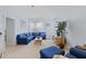 Bright living room with neutral walls, complemented by a comfortable blue sofa and natural light from the window at 3304 Cat Brier Trl, Harmony, FL 34773