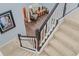 Bright staircase featuring neutral carpeting and a contrasting dark wood and white railing leading to the home's second floor at 3304 Cat Brier Trl, Harmony, FL 34773
