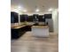 Open kitchen with dark cabinets, granite countertops, island and stainless steel appliances at 3555 Rodrick Cir, Orlando, FL 32824