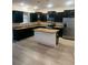 Modern kitchen boasts dark cabinetry, stainless steel appliances, and a large island with granite countertops at 3555 Rodrick Cir, Orlando, FL 32824