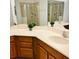 Bathroom featuring double sink vanity, light wood cabinets, and tiled walk-in shower at 3655 Zuma Way, Orlando, FL 32839