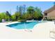Sparkling community pool surrounded by lush green trees and chaise lounge seating at 3655 Zuma Way, Orlando, FL 32839