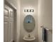 Compact half bathroom with oval mirror, modern lighting fixture, and convenient towel rack at 3655 Zuma Way, Orlando, FL 32839