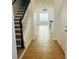 Inviting hallway featuring tile flooring, staircase, and a view into the bright, open living area at 3655 Zuma Way, Orlando, FL 32839