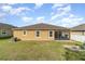 A backyard with a green lawn and a tan stucco house at 3705 Apopka Ridge Cir, Apopka, FL 32703