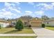 Charming single-story home featuring a manicured lawn, mature shrubbery, and a two-car garage at 3705 Apopka Ridge Cir, Apopka, FL 32703