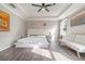 Sun-filled main bedroom has hardwood floors, a ceiling fan, and a white sofa for a calming space at 3705 Apopka Ridge Cir, Apopka, FL 32703