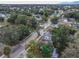 An aerial view of a residential area with mature trees and well-maintained homes on a partly cloudy day at 406 10Th St, St Cloud, FL 34769