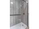 Shower featuring textured gray tile, a glass door, and chrome fixtures at 406 10Th St, St Cloud, FL 34769