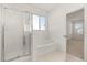 This bathroom features a glass shower, soaking tub, and a window for natural light at 4061 Flowering Peach Ln, St Cloud, FL 34772