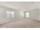 Bright bedroom featuring carpet floors, three large windows, and lots of natural light at 4061 Flowering Peach Ln, St Cloud, FL 34772