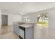Bright kitchen with stainless steel dishwasher, a view of the eating area, and a sink under the window at 4061 Flowering Peach Ln, St Cloud, FL 34772