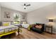 Comfortable bedroom featuring two beds, a ceiling fan, and natural light from the large window at 407 Reserve Dr, Davenport, FL 33896