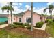 Charming pink home with a green roof, complemented by tropical landscaping and inviting curb appeal at 407 Reserve Dr, Davenport, FL 33896