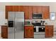 Well-equipped kitchen featuring stainless steel appliances and ample wooden cabinetry at 407 Reserve Dr, Davenport, FL 33896
