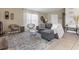 Inviting living room with a plush grey sectional, stylish rug, and ample natural light at 407 Reserve Dr, Davenport, FL 33896