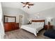 Comfortable main bedroom with wood-look floors, a ceiling fan, and a large dresser at 407 Reserve Dr, Davenport, FL 33896