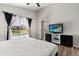 Bright main bedroom features a large window, a television, and wood-look floors at 407 Reserve Dr, Davenport, FL 33896