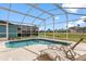 Relaxing screened-in pool area with lounge chairs and a view of the community's manicured lawn at 407 Reserve Dr, Davenport, FL 33896