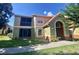 Inviting two-story condo featuring a mix of stucco and tile roof, complemented by lush green landscaping at 445 Fountainhead Cir # 264, Kissimmee, FL 34741