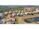 Beautiful aerial view of homes with tile roofs and backyard pools bordering a serene pond at 478 Chelsea Ave, Davenport, FL 33837