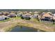 Aerial view of a home overlooking a pond, featuring a screen-enclosed pool and Mediterranean-style tile roof at 478 Chelsea Ave, Davenport, FL 33837
