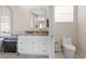 Bright bathroom with a granite countertop, a large mirror, and a toilet in its own alcove at 478 Chelsea Ave, Davenport, FL 33837