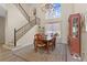 Dining room with a large window, chandelier, wood table, and staircase in a bright home at 478 Chelsea Ave, Davenport, FL 33837