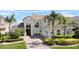 Inviting two-story home with lush landscaping, arched entry, and a three-car garage at 478 Chelsea Ave, Davenport, FL 33837