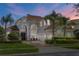 Beautiful home with mature landscaping, a red tile roof, arched entry, and a three-car garage at 478 Chelsea Ave, Davenport, FL 33837