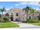 Stunning two-story home featuring a tile roof, arched windows, and meticulously landscaped front yard at 478 Chelsea Ave, Davenport, FL 33837