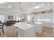 Open-concept kitchen with white cabinets, an island, quartz countertops, and seamless flow into the living room at 478 Chelsea Ave, Davenport, FL 33837