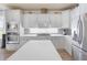 Modern kitchen with white cabinetry, stainless steel appliances, and a spacious center island perfect for cooking at 478 Chelsea Ave, Davenport, FL 33837