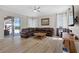 Bright living room with a leather couch, large windows, ceiling fan, and access to an outdoor living space at 478 Chelsea Ave, Davenport, FL 33837