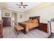 Spacious main bedroom with tray ceilings, dark wood furniture, and hardwood floors at 478 Chelsea Ave, Davenport, FL 33837