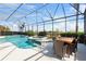 Relaxing screened-in pool and spa area with patio furniture and a view of the surrounding landscape at 478 Chelsea Ave, Davenport, FL 33837