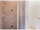 Detailed view of a shower with neutral tile, glass door, and chrome shower head at 478 Chelsea Ave, Davenport, FL 33837