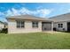 Backyard view features a well-kept lawn, a screened-in patio, and the home's exterior at 5151 Twin Lakes Blvd, St Cloud, FL 34772