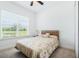 Bright bedroom with ceiling fan and large window looking out to a lush green lawn at 5151 Twin Lakes Blvd, St Cloud, FL 34772