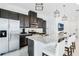Modern kitchen with stainless steel appliances, granite countertops, and a breakfast bar with white chairs at 5151 Twin Lakes Blvd, St Cloud, FL 34772