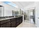 An elegant main bathroom with double sinks, granite countertops, and a spacious glass shower at 5151 Twin Lakes Blvd, St Cloud, FL 34772