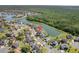 Aerial view of a neighborhood with homes surrounding a large lake and lush green forest at 5516 Willow Bend Trl, Kissimmee, FL 34758