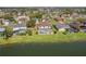 Aerial view of homes surrounding a pond, each with screened-in pools and well-manicured lawns at 5516 Willow Bend Trl, Kissimmee, FL 34758