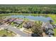 Aerial view of homes near a pond with lush green trees in the background at 5516 Willow Bend Trl, Kissimmee, FL 34758