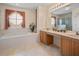 Bright bathroom featuring double sinks, a bathtub, and a separate glass door shower at 5516 Willow Bend Trl, Kissimmee, FL 34758